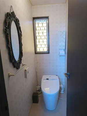 a bathroom with a toilet with a mirror and a window at Homestay Intimo Amigo in Tokyo