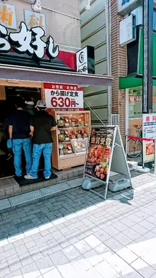 a man standing outside of a store with a sign in front at Homestay Intimo Amigo in Tokyo