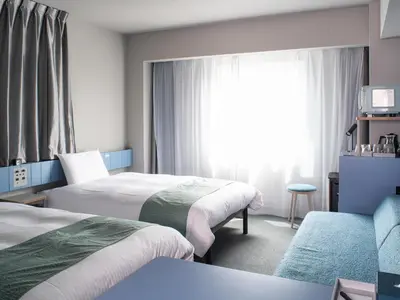 a hotel room with two beds and a window at Vessel Inn Takadanobaba Station in Tokyo