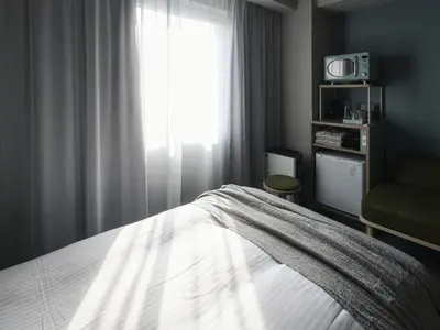 a bedroom with a bed and a window at Vessel Inn Takadanobaba Station in Tokyo