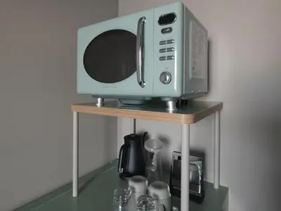 a microwave sitting on top of a small table at Vessel Inn Takadanobaba Station in Tokyo