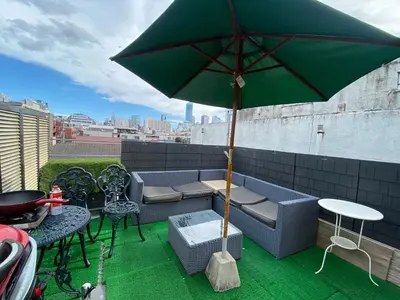 a green umbrella sitting on top of a patio at \u65b0\u5bbf\u99c52\u5206 jr\u65b0\u5927\u4e45\u4fdd\u99c5\u5f92\u6b698\u5206 \u6b4c\u821e\u4f0e\u753a\u5f92\u6b6910\u5206 in Tokyo