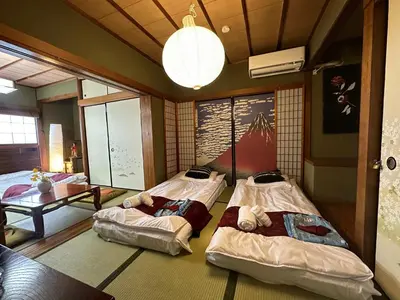 a room with three beds and a table in it at \u65b0\u5bbf\u99c52\u5206 jr\u65b0\u5927\u4e45\u4fdd\u99c5\u5f92\u6b698\u5206 \u6b4c\u821e\u4f0e\u753a\u5f92\u6b6910\u5206 in Tokyo
