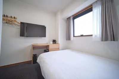 a hotel room with a bed and a flat screen tv at Ano Hotel Asakusa in Tokyo