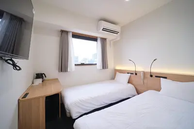 a hotel room with two beds and a television at Ano Hotel Asakusa in Tokyo