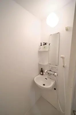 a white bathroom with a sink and a mirror at Ano Hotel Asakusa in Tokyo