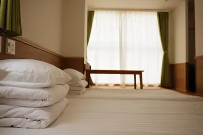 a bedroom with a bed with pillows and a window at \u82e5\u6d45\u8349\u548c\u5fc3\u30db\u30c6\u30eb in Tokyo