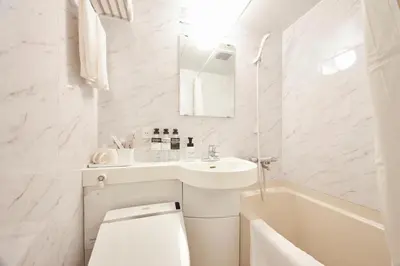 a white bathroom with a sink and a toilet and a tub at \u82e5\u6d45\u8349\u548c\u5fc3\u30db\u30c6\u30eb in Tokyo