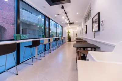 a bar in a restaurant with a row of stools at Asakusa YOSHII Designer Hotel in Tokyo