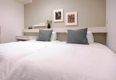 a bedroom with a large white bed with two pillows at Asakusa YOSHII Designer Hotel in Tokyo