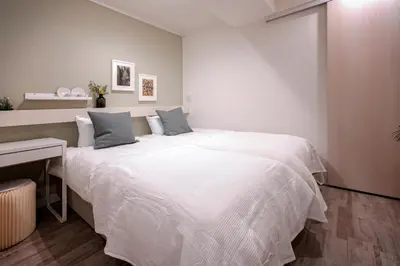 a bedroom with a large white bed and a desk at Asakusa YOSHII Designer Hotel in Tokyo