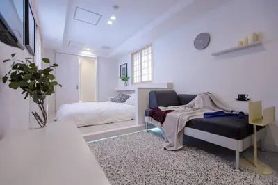 a white room with a bed and a couch at Asakusa YOSHII Designer Hotel in Tokyo