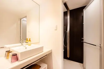 a white bathroom with a sink and a mirror at karaksa hotel colors Tokyo Yaesu in Tokyo