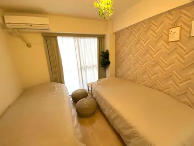 a bedroom with two beds and a window at \u526f\u90fd\u5fc3\u7dda\u6c60\u888b\u99c5C1\u51fa\u53e3\u304b\u3089\u5f92\u6b693\u5206 1\u304b\u6708\u4ee5\u4e0a\u306e\u3054\u4e88\u7d04\u306f6\u5272Off in Tokyo
