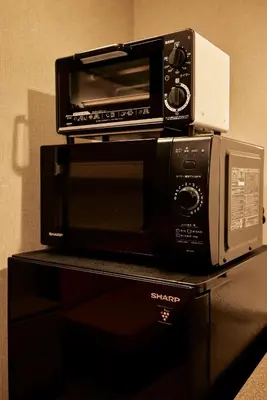 a toaster oven sitting on top of a microwave at Section L Hatchobori in Tokyo