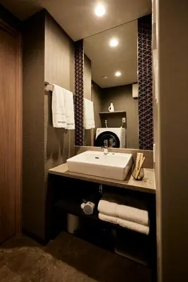 a bathroom with a sink and a mirror and towels at Section L Hatchobori in Tokyo