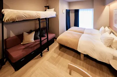 a bedroom with two bunk beds and a couch at Section L Hatchobori in Tokyo