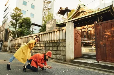 two women walking down a street next to a building at Section L Hatchobori in Tokyo