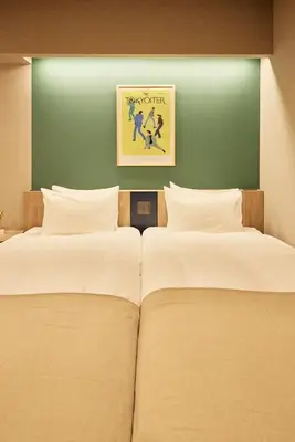 two beds in a room with a green wall at Section L Hatchobori in Tokyo