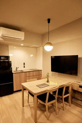 a living room with a table and a kitchen at Section L Hatchobori in Tokyo