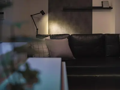 a living room with a leather couch and a lamp at Ustay ueno in Tokyo