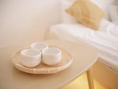 three white bowls on a tray on a table next to a bed at Ustay ueno in Tokyo