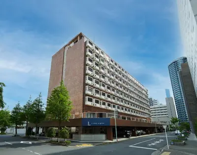 a tall red brick building on a city street at L stay & grow Harumi in Tokyo