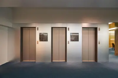 a row of elevators in a building at L stay & grow Harumi in Tokyo