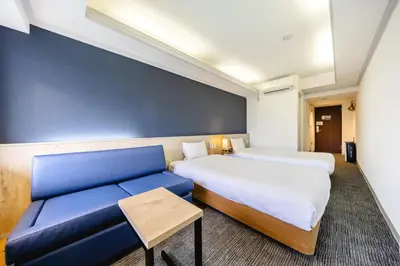 a hotel room with two beds and a couch at L stay & grow Harumi in Tokyo