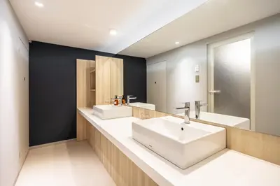 a bathroom with two sinks and a large mirror at L stay & grow Harumi in Tokyo