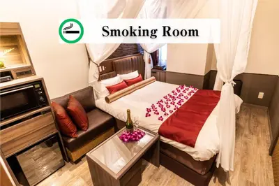 a room with a bed and a couch with a smoking room at BaliAn Resort Forest Ikebukuro in Tokyo