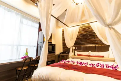 a bedroom with a canopy bed with white curtains at BaliAn Resort Forest Ikebukuro in Tokyo