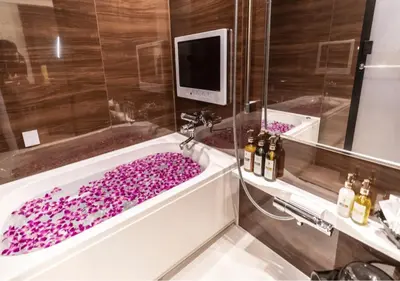 a bathroom with a bath tub filled with purple flowers at BaliAn Resort Forest Ikebukuro in Tokyo