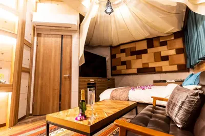 a room with a bed and a couch and a table at Hotel Bali An Resort Shinjuku Forest in Tokyo