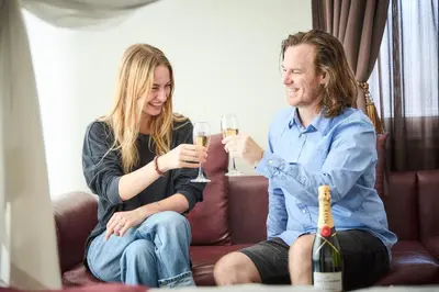 a man and woman sitting on a couch drinking champagne at Hotel Bali An Resort Shinjuku Forest in Tokyo