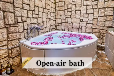 an open air bathtub with pink flowers on it at Petit Bali Ikebukuro in Tokyo