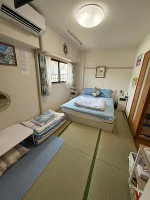 a bedroom with two beds and a window at \u90fd\u5fc3\u306e\u5bb630 square meter king size bed, step meter, 3-person room201 in Tokyo