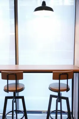 a table and two stools in front of a window at N Plus Hotel Akihabara in Tokyo