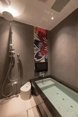 a bathroom with a tub with a shower and a television at HOTEL\u307f\u306a\u3068-MINATO- in Tokyo