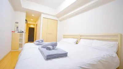a bedroom with a white bed with towels on it at TOKYO ICHIBAN SHINJUKU in Tokyo