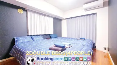 a bedroom with a blue bed and a window at TOKYO ICHIBAN SHINJUKU in Tokyo