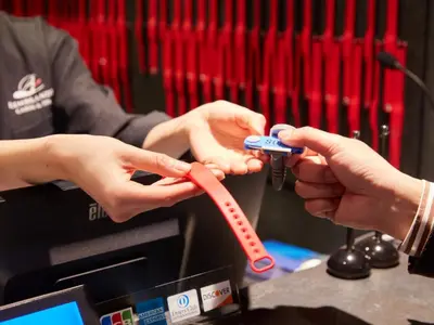 a person tying a red ribbon on a remote control at Rembrandt Cabin & Spa Shimbashi - Caters to Men in Tokyo