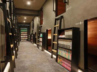 a row of bookshelves in a book store at Rembrandt Cabin & Spa Shimbashi - Caters to Men in Tokyo