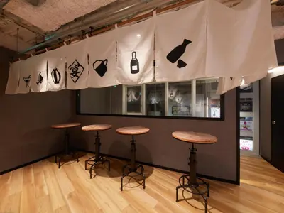 a room with three bar stools in front of a wall with signs on it at Rembrandt Cabin & Spa Shimbashi - Caters to Men in Tokyo