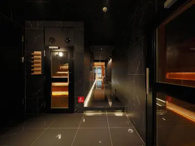 a dark hallway with a door and a tiled floor at Rembrandt Cabin & Spa Shimbashi - Caters to Men in Tokyo