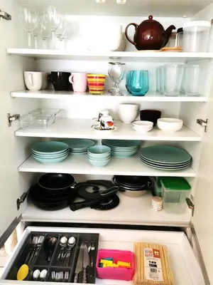 a white cabinet filled with plates and dishes at Bell house in Tokyo