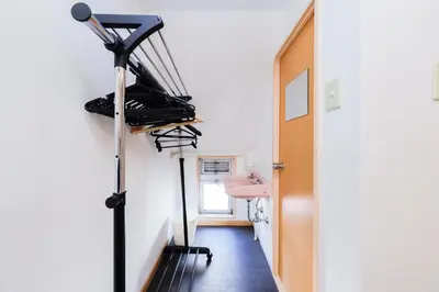 a room with a hallway with a rack of shoes at Grace Heiwajima by Tranova in Tokyo