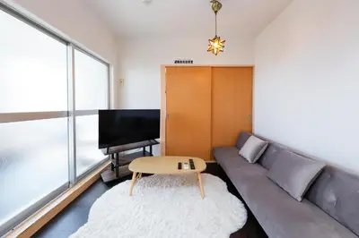 a living room with a couch and a television at Grace Heiwajima by Tranova in Tokyo