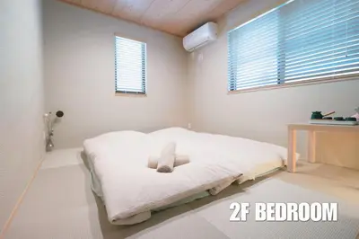 a bedroom with a white bed with two windows at \u65b0\u5bbf\u4e2d\u5fc3\u9ad8\u7d1a\u7a00\u6709\u65b0\u5efa\u5225\u5885\uff0cJR\u7dda\u65b0\u5927\u4e45\u4fdd\u5f92\u6b654\u5206\u9418\u9732\u53f0\u514d\u8cbbWi-Fi in Tokyo