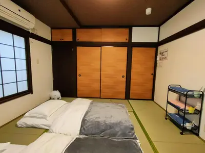 a bedroom with a large bed and wooden doors at KIKI HOUSE in Tokyo